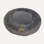 Cama Dona Ceiba antiestrés para perros y gatos en color rosado, diseñada con bordes elevados y materiales suaves para ofrecer un descanso cómodo.